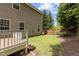 Angle view of exterior: Wooden deck has steps down to a small yard with healthy grass at 1928 Grace Point Rd, Morrisville, NC 27560