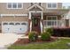 Inviting home exterior with a two-car garage and covered porch with brick and white pillars at 1928 Grace Point Rd, Morrisville, NC 27560