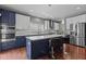 Modern kitchen featuring stainless appliances, two-tone cabinetry, and a large island with bar seating at 1928 Grace Point Rd, Morrisville, NC 27560