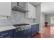 Close-up of kitchen with stainless steel appliances, blue cabinets, and an open-concept view at 1928 Grace Point Rd, Morrisville, NC 27560