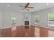Open concept living room features hardwood flooring, a fireplace and a ceiling fan at 1928 Grace Point Rd, Morrisville, NC 27560