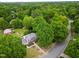 View of a home with a lush, wooded yard and surrounding neighborhood from above at 2021 Sunnybrook Dr, Burlington, NC 27215