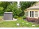 A spacious backyard with a shed, green grass and stepping stones leading to the sunroom at 2021 Sunnybrook Dr, Burlington, NC 27215