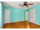 Spacious bedroom with blue walls, hardwood floors, a ceiling fan, and closets at 2021 Sunnybrook Dr, Burlington, NC 27215