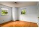 Bright bedroom featuring natural light, hardwood flooring, and two windows at 2021 Sunnybrook Dr, Burlington, NC 27215