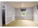 Neutral bedroom with a ceiling fan, gray walls and a window with decorative curtain at 2021 Sunnybrook Dr, Burlington, NC 27215
