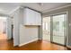 Bright kitchen nook area with wood floors, white cabinets and sliding glass doors at 2021 Sunnybrook Dr, Burlington, NC 27215
