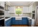 Stylish kitchen with blue cabinets, stainless steel appliances, and a farmhouse sink at 2021 Sunnybrook Dr, Burlington, NC 27215