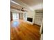 Open-concept living room with hardwood floors, fireplace, and sliding glass doors at 2021 Sunnybrook Dr, Burlington, NC 27215