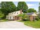 Home featuring a brick exterior, sunroom, large lot, and a concrete patio at 2021 Sunnybrook Dr, Burlington, NC 27215
