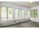 Bright sunroom with multiple windows and white brick walls at 2021 Sunnybrook Dr, Burlington, NC 27215