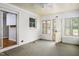 Cozy sunroom with carpet, windows, white brick walls, and ceiling fan at 2021 Sunnybrook Dr, Burlington, NC 27215