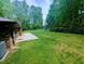 Large grassy backyard with brick home and fence at 2100 Possum Trot Rd, Wake Forest, NC 27587