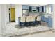Charming kitchen featuring blue cabinets, stainless steel appliances, an island with breakfast bar, and brick-laid flooring at 2100 Possum Trot Rd, Wake Forest, NC 27587