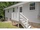 Exterior back entrance with white siding, a small deck, and stairs leading to the yard at 2222 Oak Ridge Blvd, Durham, NC 27707
