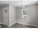 Bright dining room featuring gray walls, wood flooring, modern chandelier, and a natural light filled window at 2222 Oak Ridge Blvd, Durham, NC 27707
