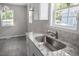 Updated kitchen sink is well-lit by large windows and features granite counters at 2222 Oak Ridge Blvd, Durham, NC 27707