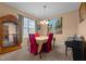 An inviting dining room with carpet, tan walls, a piano, a decorative hutch, and a hanging light fixture at 2503 Macdougall Dr, Burlington, NC 27217