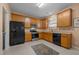A kitchen featuring wood cabinets, tile floor, and stainless steel and black appliances at 2503 Macdougall Dr, Burlington, NC 27217