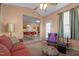 A living room open to a dining and kitchen area featuring tan walls, carpet, and large windows at 2503 Macdougall Dr, Burlington, NC 27217