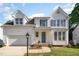 Beautiful white home with a brick walkway, lamp post and manicured green lawn at 2612 Alder Ridge Ln, Raleigh, NC 27603