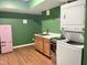Kitchenette with wooden cabinets, pink refrigerator, and stacked washer/dryer at 2612 Alder Ridge Ln, Raleigh, NC 27603