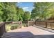Outdoor wooden deck with a fenced in backyard surrounded by lush green trees and grass at 2708 Tryon Pines Dr, Raleigh, NC 27603