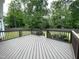 Outdoor wooden deck with a fenced in backyard surrounded by lush green trees and grass at 2708 Tryon Pines Dr, Raleigh, NC 27603
