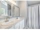 Elegant bathroom featuring a double sink vanity with framed mirrors and a shower with a curtain at 2708 Tryon Pines Dr, Raleigh, NC 27603