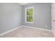 Cozy bedroom featuring neutral carpet, a window that provides natural light, and a door at 2708 Tryon Pines Dr, Raleigh, NC 27603