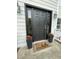 A stylish black front door with sidelights, potted flowers, and a welcome mat at 2708 Tryon Pines Dr, Raleigh, NC 27603