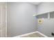 Bright laundry room with gray walls, wood flooring, and a white shelf above the washer/dryer hookups at 2708 Tryon Pines Dr, Raleigh, NC 27603