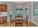 Sunlit eat-in kitchen area with wood table, chairs, and large windows overlooking the backyard at 2723 Cameron Pond Dr, Cary, NC 27519