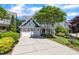 Inviting blue two-story home featuring a spacious driveway and a well-maintained front yard with mature trees at 2723 Cameron Pond Dr, Cary, NC 27519