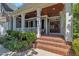 Close-up of a charming front porch with brick steps, white columns, and a beautiful wood-stained front door at 2723 Cameron Pond Dr, Cary, NC 27519