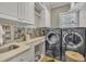 Convenient laundry room with modern washer/dryer, countertop, and custom cabinets at 2723 Cameron Pond Dr, Cary, NC 27519