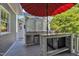 Covered outdoor kitchen features a granite countertop, stainless steel appliances, mini fridge, grill and ample preparation space at 2723 Cameron Pond Dr, Cary, NC 27519