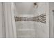 Walk-in shower with a built-in bench and modern tiling with decorative mosaic stripe and a brushed nickel shower head at 2723 Cameron Pond Dr, Cary, NC 27519