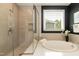 Bright bathroom boasts a soaking tub, tiled shower and natural light from the window at 273 Scarlet Tanager Cir, Holly Springs, NC 27540