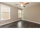A bright, empty bedroom with three windows and vinyl wood flooring at 273 Scarlet Tanager Cir, Holly Springs, NC 27540