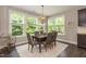 Bright dining room with large windows, stylish light fixture and seating for six at 273 Scarlet Tanager Cir, Holly Springs, NC 27540