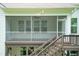 Back exterior view of the house, showing the screened porch and stairs to the patio at 273 Scarlet Tanager Cir, Holly Springs, NC 27540