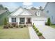 Beautifully landscaped, light and airy white home with a charming front porch and manicured lawn at 273 Scarlet Tanager Cir, Holly Springs, NC 27540