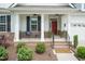 Inviting front porch with brick accents, seating, and a view of the landscaped yard at 273 Scarlet Tanager Cir, Holly Springs, NC 27540