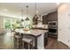 Kitchen island with granite countertop, stainless steel appliances, seating, and eat-in area at 273 Scarlet Tanager Cir, Holly Springs, NC 27540