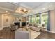 Bright living room with fireplace, hardwood floors, coffered ceiling, and large windows offering scenic views at 273 Scarlet Tanager Cir, Holly Springs, NC 27540