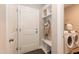 This practical mud room includes laundry, storage shelves, and coat hooks near the home entry at 273 Scarlet Tanager Cir, Holly Springs, NC 27540