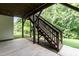 Covered patio with access to backyard, featuring staircase to upper level and well-manicured lawn at 273 Scarlet Tanager Cir, Holly Springs, NC 27540