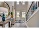 Bright foyer features a staircase, wood floors, a stylish mirror, and a console table with decor at 3004 Dog Rose Dr # 309, Durham, NC 27703
