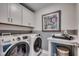 Bright laundry room with white cabinets, modern washer and dryer, and countertop folding space at 3004 Dog Rose Dr # 309, Durham, NC 27703
